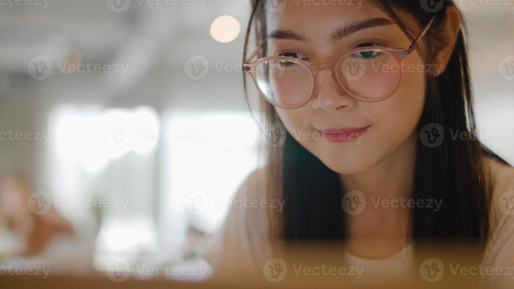 mujeres asiáticas independientes que trabajan en una computadora portátil en la oficina. joven empresaria de asia usando la computadora para el comercio, enviar correo electrónico, trabajo digital en Internet en la mesa en el concepto de lugar de trabajo. foto