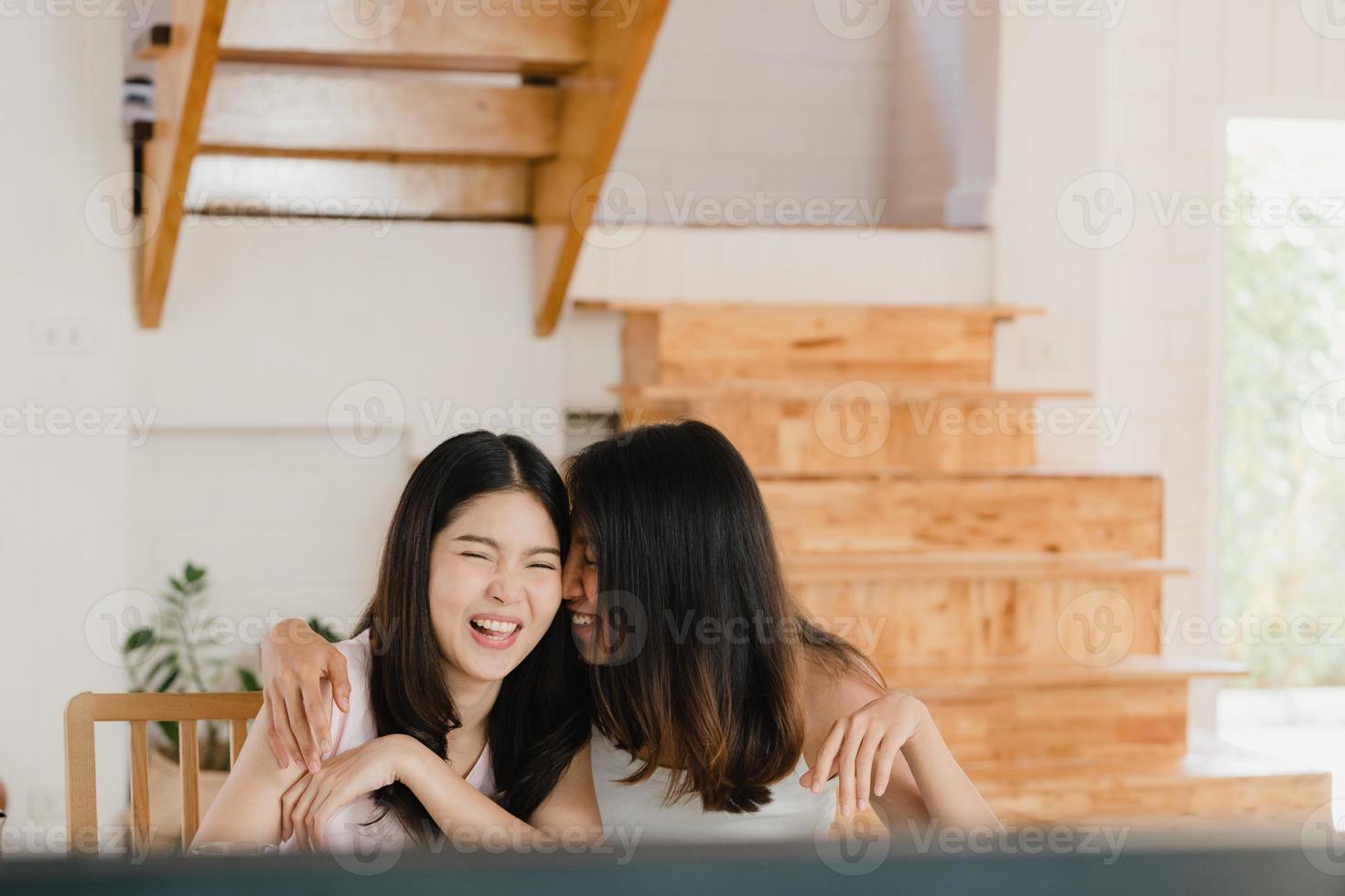 Asian Lesbian lgbtq women couple have breakfast at home, Young Asia lover girls happy watching TV while drink juice, corn flakes cereal and milk in bowl on table in kitchen in the morning concept. photo