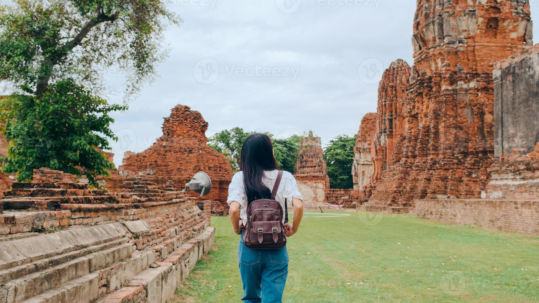 mujer asiática viajera que pasa un viaje de vacaciones en ayutthaya, tailandia, mujer mochilera japonesa disfruta de su viaje en un hito increíble en la ciudad tradicional. concepto de vacaciones de viaje de mujeres de estilo de vida. foto