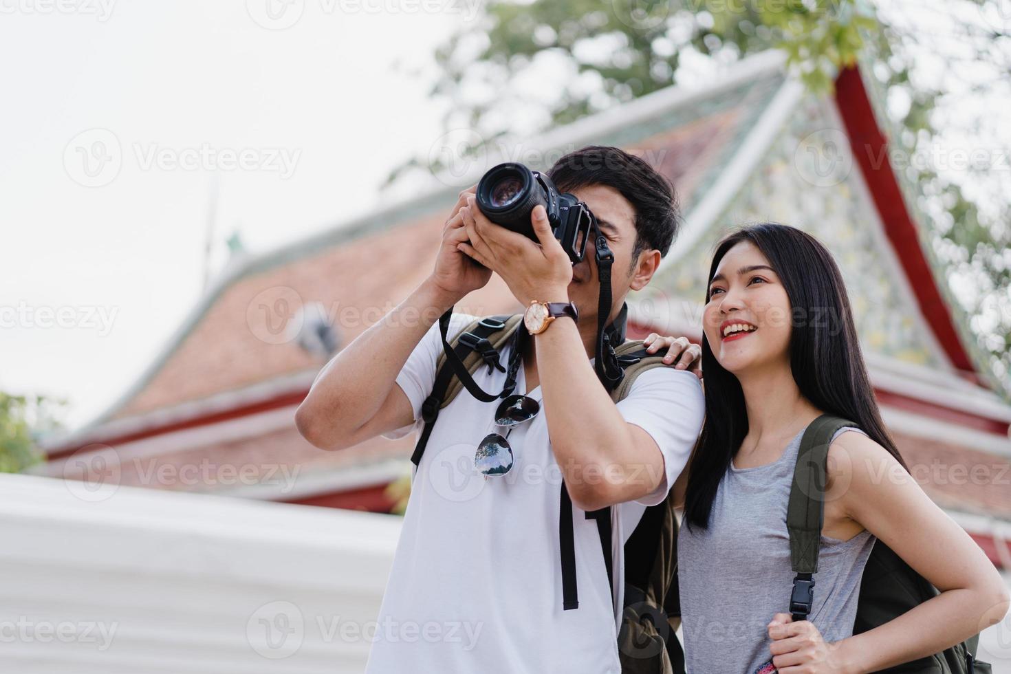 Traveler Asian couple using camera for take a picture while spending holiday trip at Bangkok, Thailand, couple enjoy journey at amazing landmark in city. Lifestyle couple travel in city concept. photo