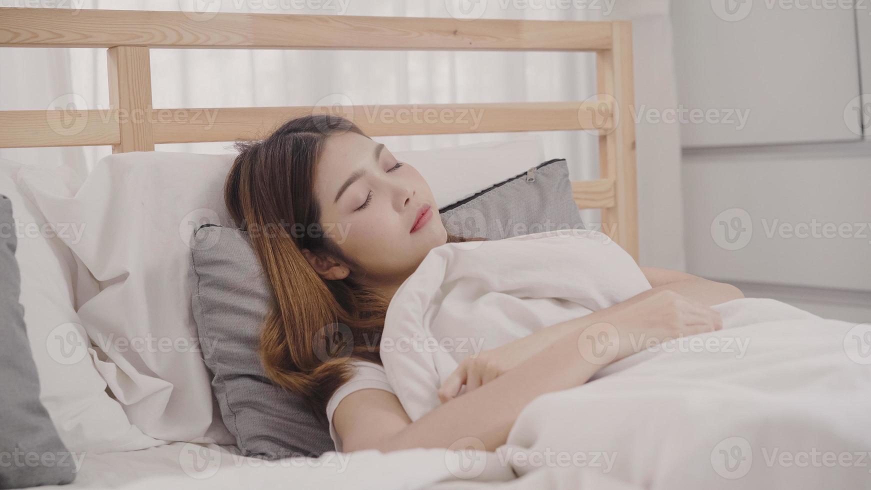 Asian woman dreaming while sleeping on bed in bedroom, Beautiful japanese female using relax time lying on bed at home. Lifestyle women using relax time at home concept. photo