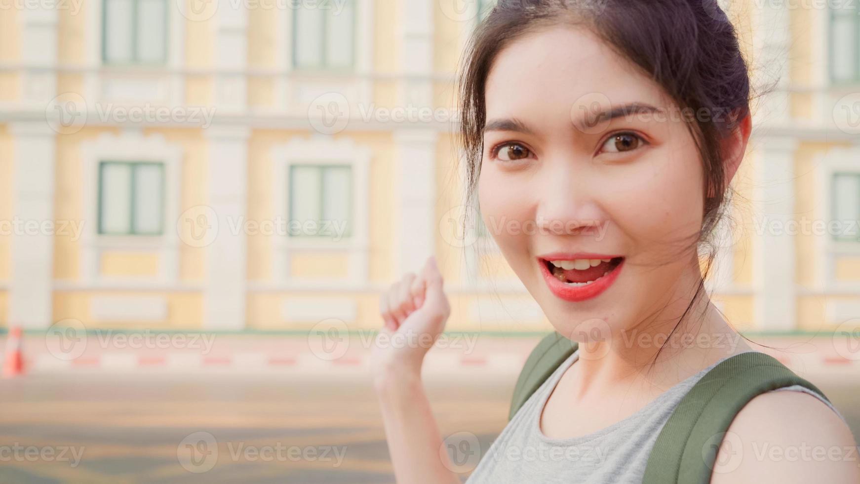 mujer bloguera asiática viaja en bangkok, tailandia, mujer mochilera que usa teléfono móvil hace vlog y vive en las redes sociales mientras pasa un buen rato en un viaje de vacaciones. las mujeres viajan en concepto de ciudad. foto