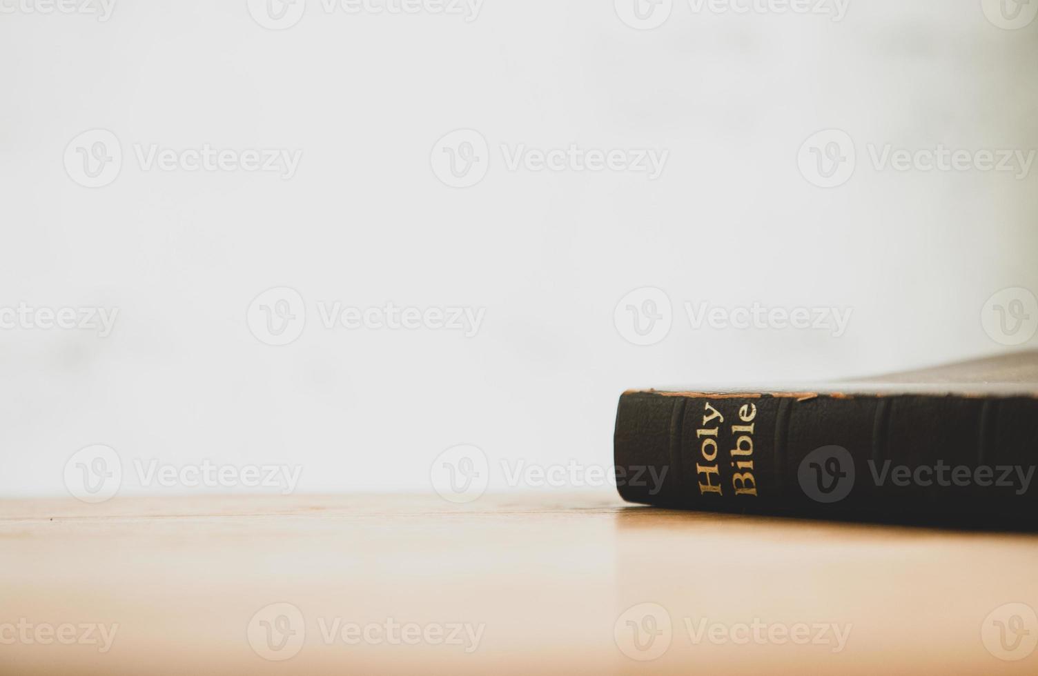 Holy bible with note book and pencil on wooden table, copy space photo