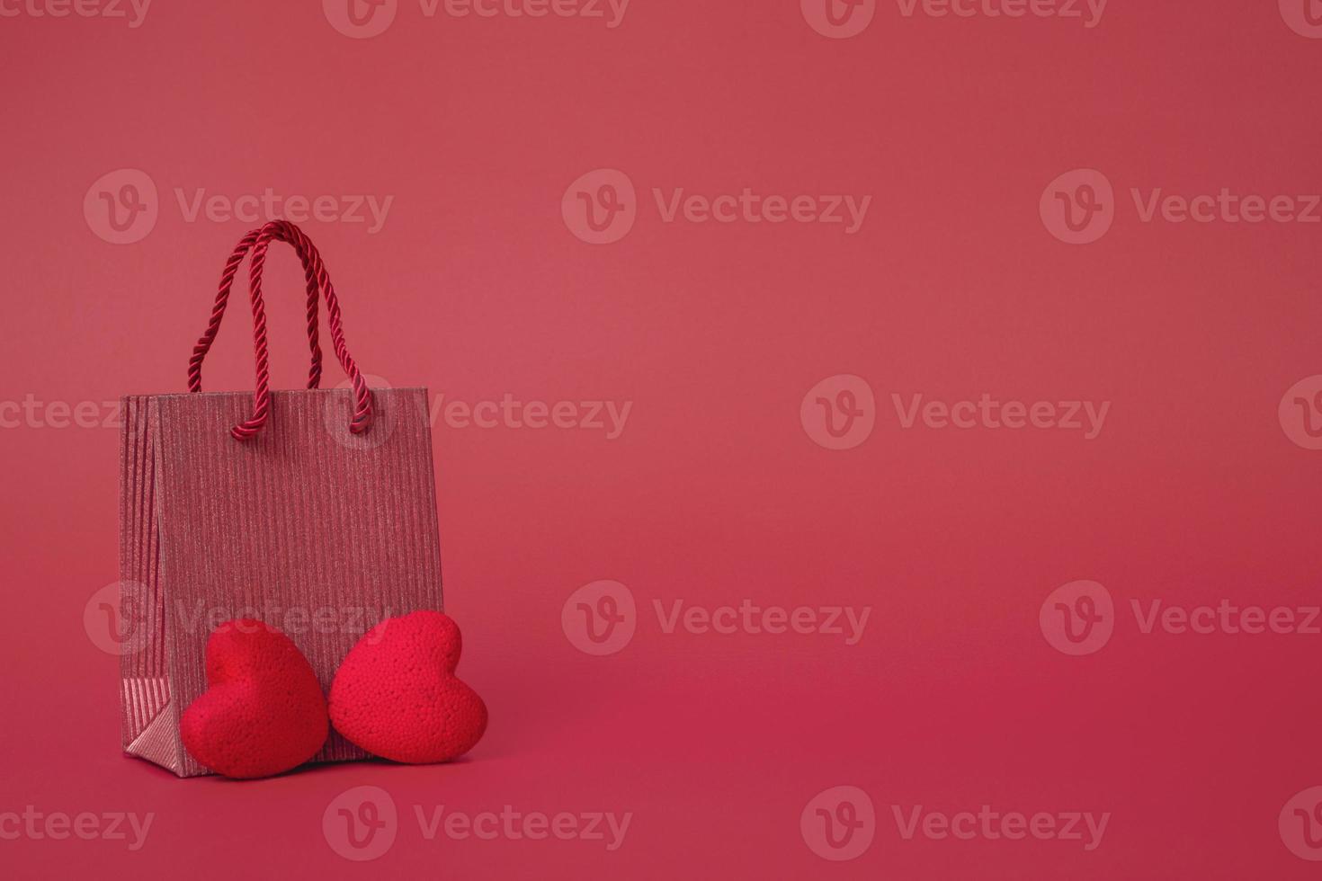 On a red background, a gift bag with cosmetics. The concept of valentines day, mothers day, sale. copy space, closeup photo