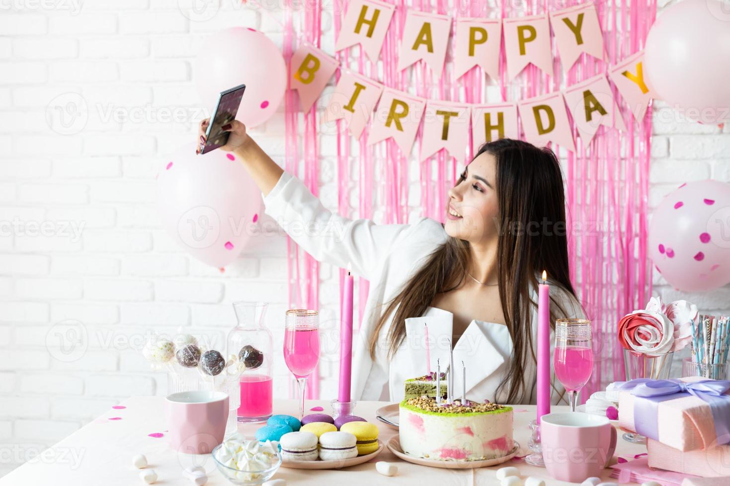 hermosa mujer celebrando la fiesta de cumpleaños tomando selfie foto