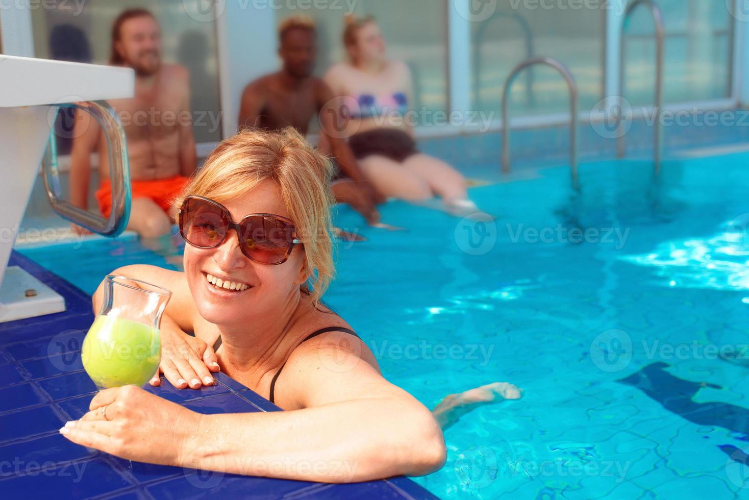 mujer rubia con traje de baño negro y gafas de sol junto al borde de la  piscina con amigos. verano. concepto de vacaciones y deporte. 5497623 Foto  de stock en Vecteezy