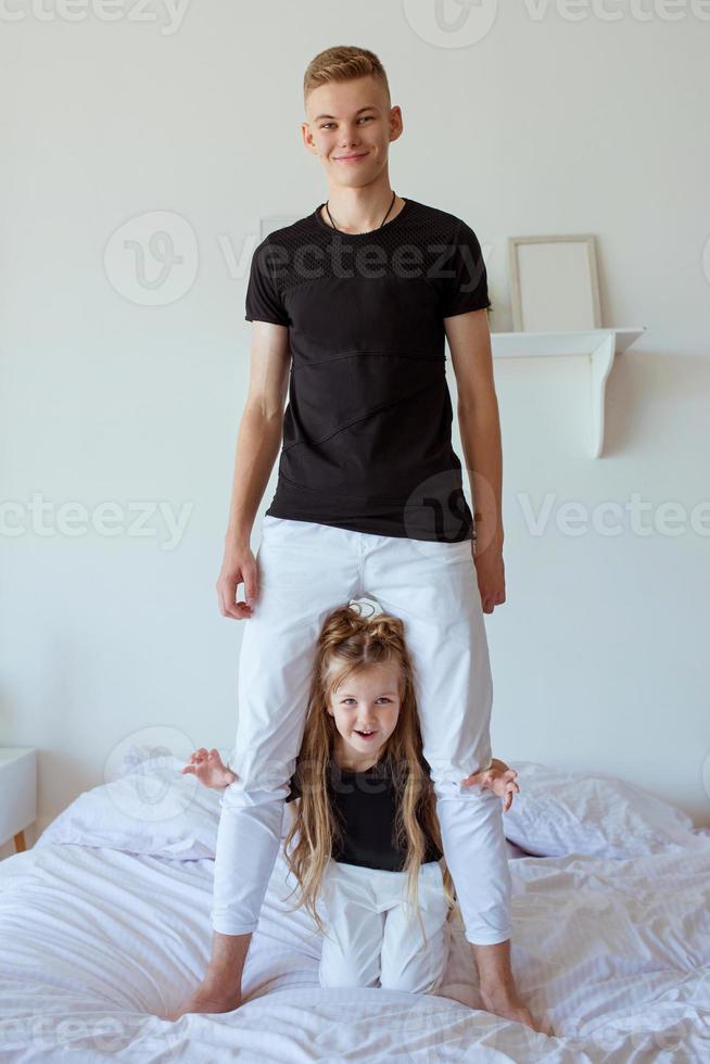 caucasian siblings - teenager boy brother and little girl sister in bedroom modern loft interior. Typical family lifestyle photo