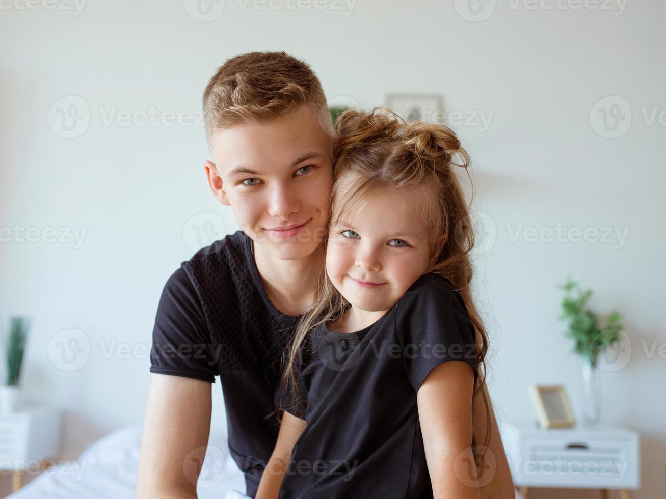 caucasian siblings - teenager boy brother and little girl sister in bedroom modern loft interior. Typical family lifestyle photo