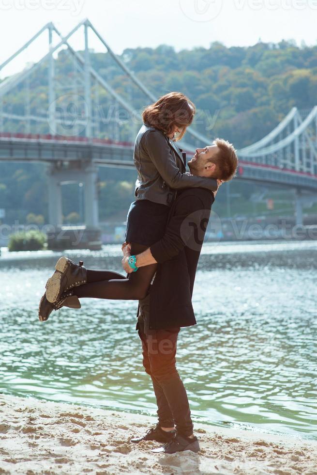 beautiful amazing funny cheerful young couple walking outdoor by the river on bridge background. Girlfriend and boyfriend. Family, fun, love and friendship concept photo