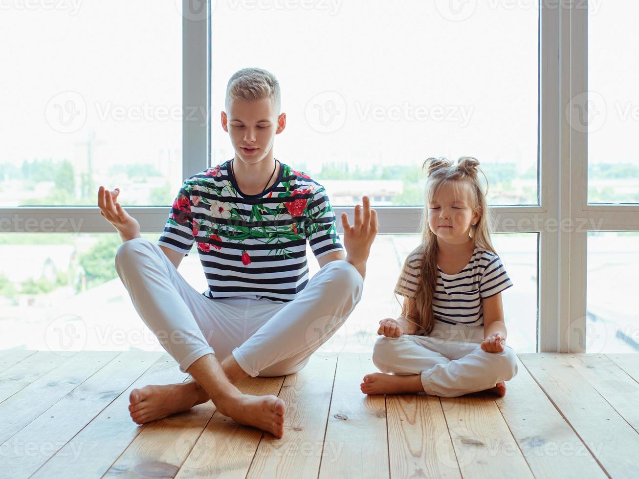 caucasian siblings playing super heroes by the window. Family, relatives, relationship and game concept. photo