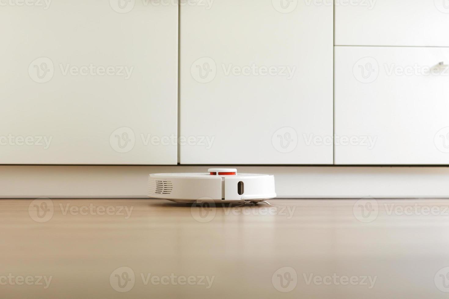 Robot vacuum cleaner performs automatic cleaning of the apartment at a certain time. white robot vacuum cleaner. home cleaning. Smart home. selective focus photo