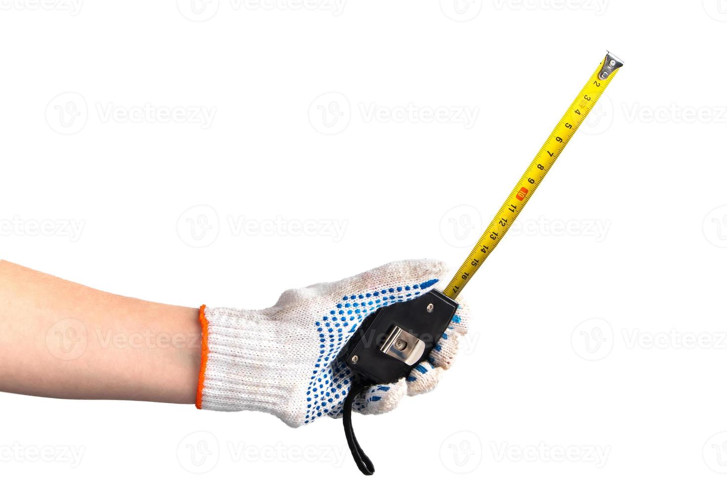 la mano con guantes de trabajo blancos tiene cinta métrica. Feliz Día del Trabajo. el trabajador masculino mide la longitud con una herramienta manual para reparar. foto