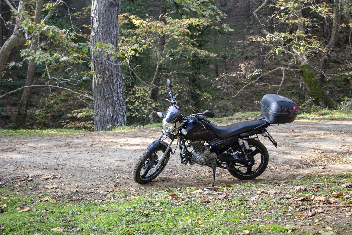 Motorcycle alone on the road. Touring in the forest. Motorcycle on the forest road.  Motorcycle in nature parking on a path. photo