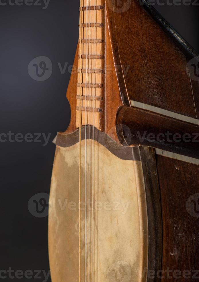 part ancient Asian stringed musical instrument on black background with backlight photo