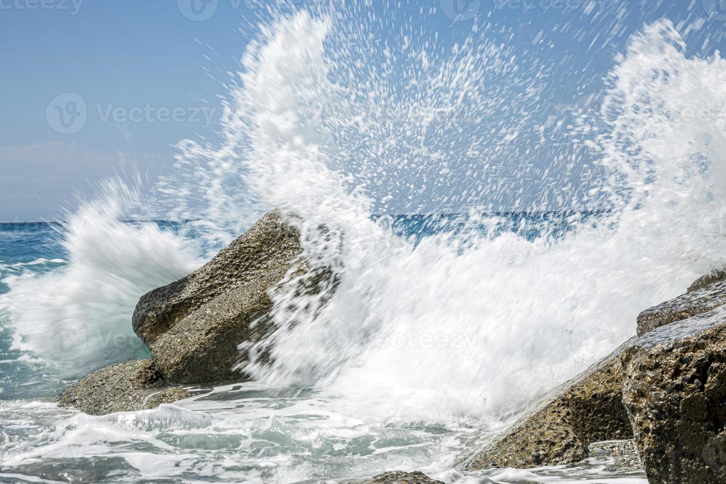 High wave breaking on the rocks of the coastline. photo