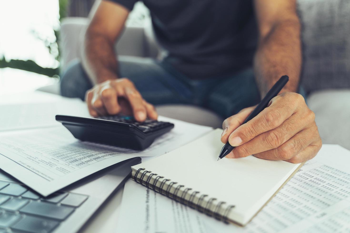 Man is calculating annual tax with calculator and filling form of Individual Income Tax Return. Season to pay Tax and Budget planning concept. photo