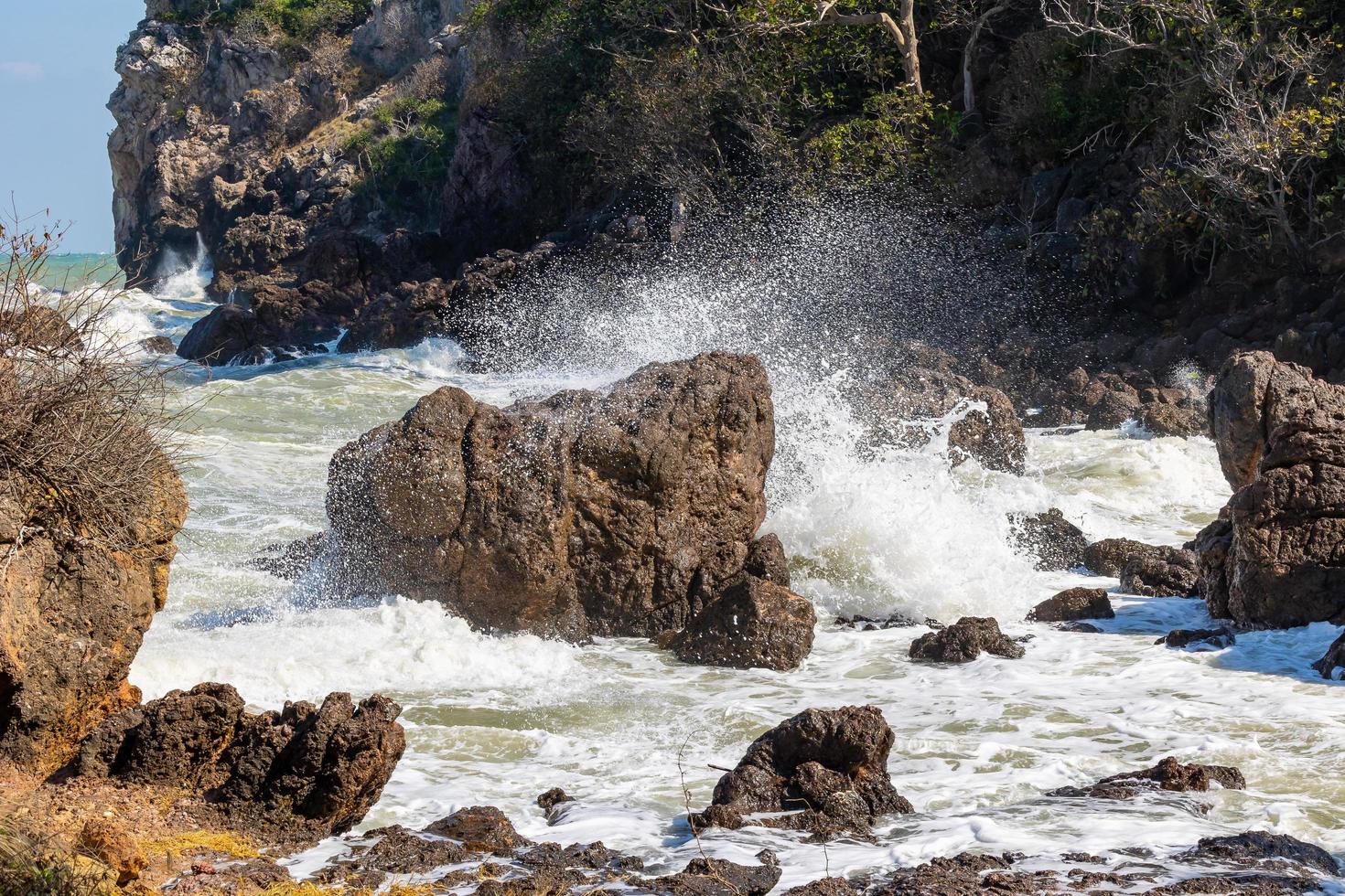 Waves and strong sea winds swept the rocks and shoals. Waves and sea breezes crash against rocks and shores. photo