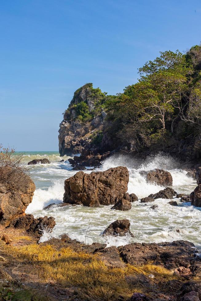 Waves and strong sea winds swept the rocks and shoals. Waves and sea breezes crash against rocks and shores. photo