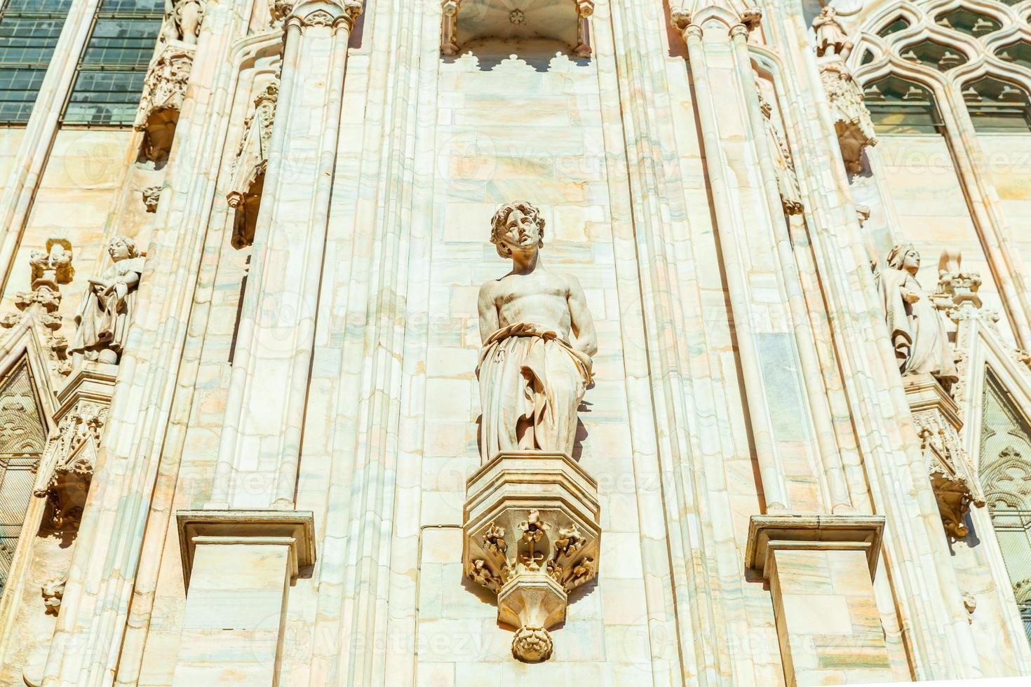 Facade of Milan Cathedral Duomo di Milano with Gothic spires and white marble statues. Top tourist attraction on piazza in Milan, Lombardia, Italy. Wide angle view of old Gothic architecture and art. photo