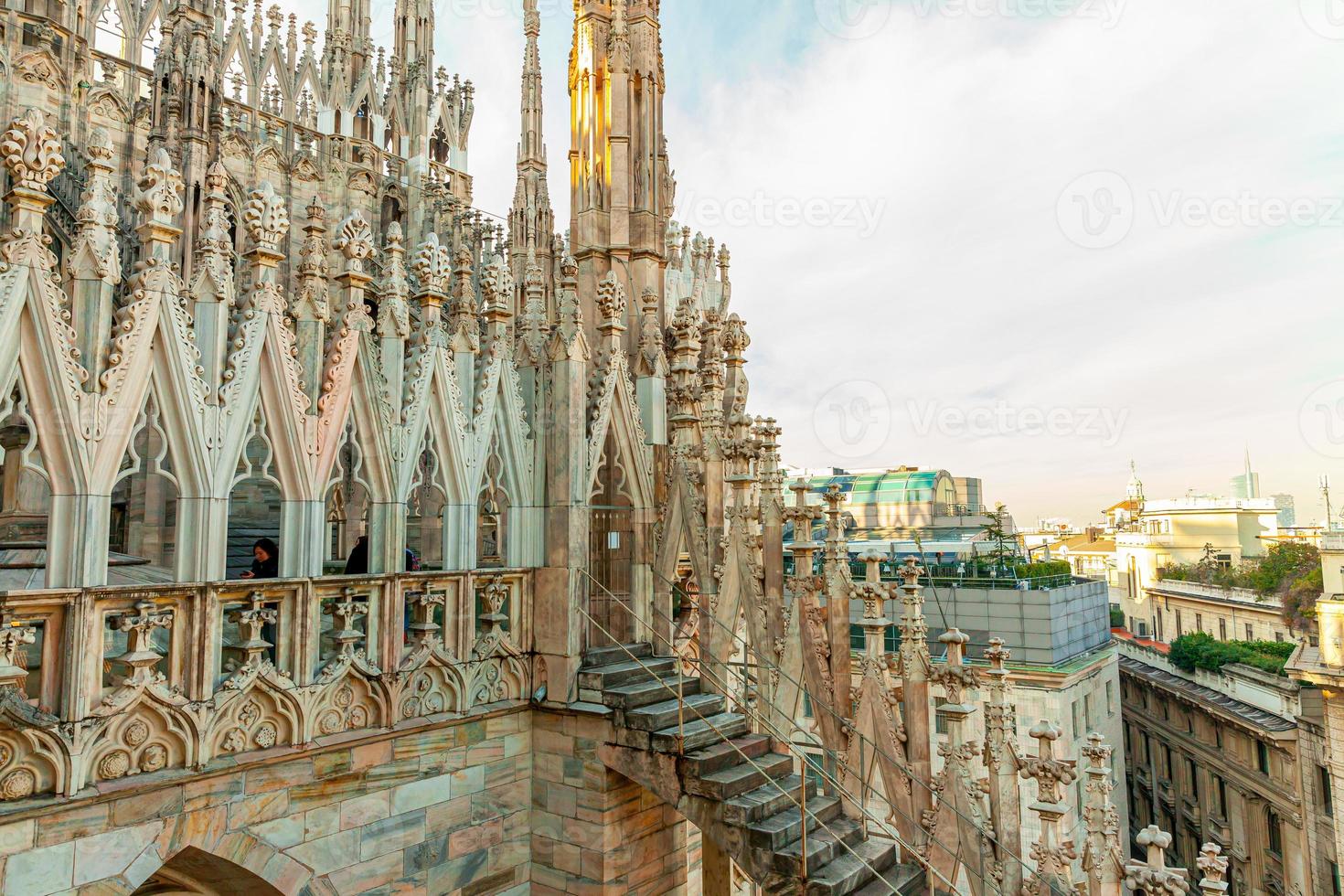 Roof of Milan Cathedral Duomo di Milano with Gothic spires and white marble statues. Top tourist attraction on piazza in Milan, Lombardia, Italy. Wide angle view of old Gothic architecture and art. photo