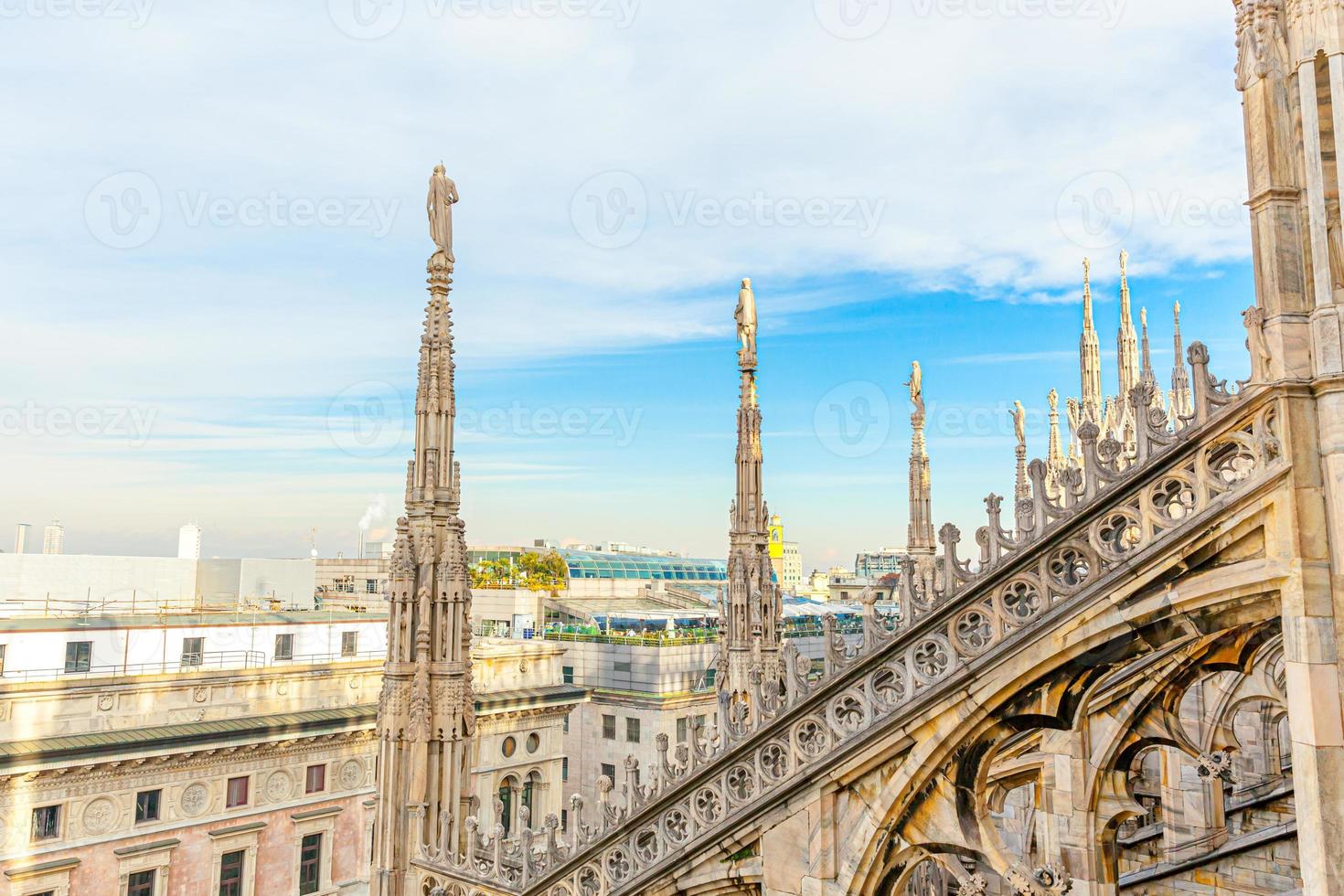 Roof of Milan Cathedral Duomo di Milano with Gothic spires and white marble statues. Top tourist attraction on piazza in Milan, Lombardia, Italy. Wide angle view of old Gothic architecture and art. photo