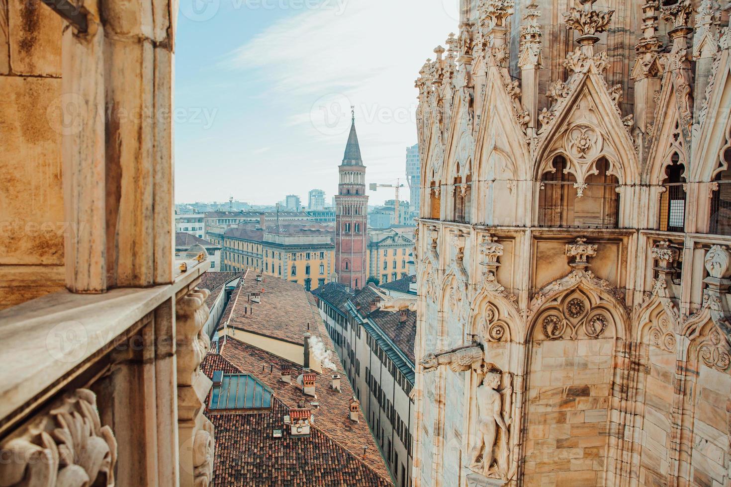 Roof of Milan Cathedral Duomo di Milano with Gothic spires and white marble statues. Top tourist attraction on piazza in Milan, Lombardia, Italy. Wide angle view of old Gothic architecture and art. photo