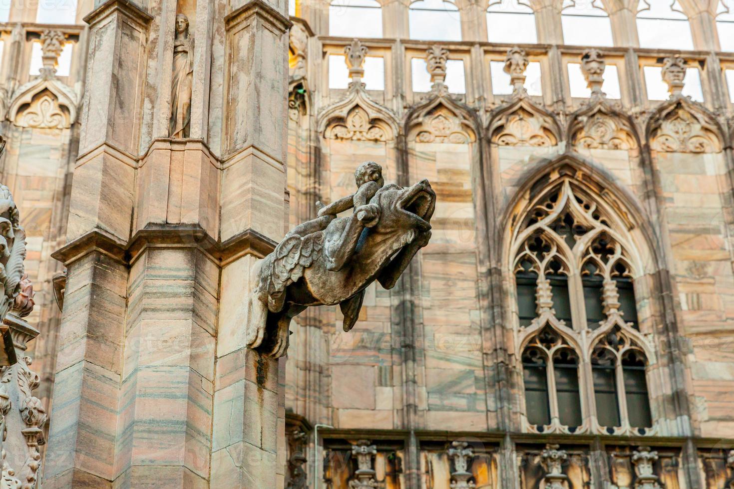 Roof of Milan Cathedral Duomo di Milano with Gothic spires and white marble statues. Top tourist attraction on piazza in Milan, Lombardia, Italy. Wide angle view of old Gothic architecture and art. photo
