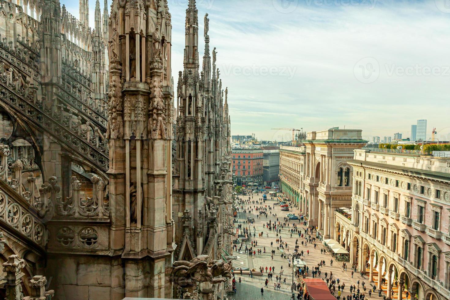 Roof of Milan Cathedral Duomo di Milano with Gothic spires and white marble statues. Top tourist attraction on piazza in Milan, Lombardia, Italy. Wide angle view of old Gothic architecture and art. photo