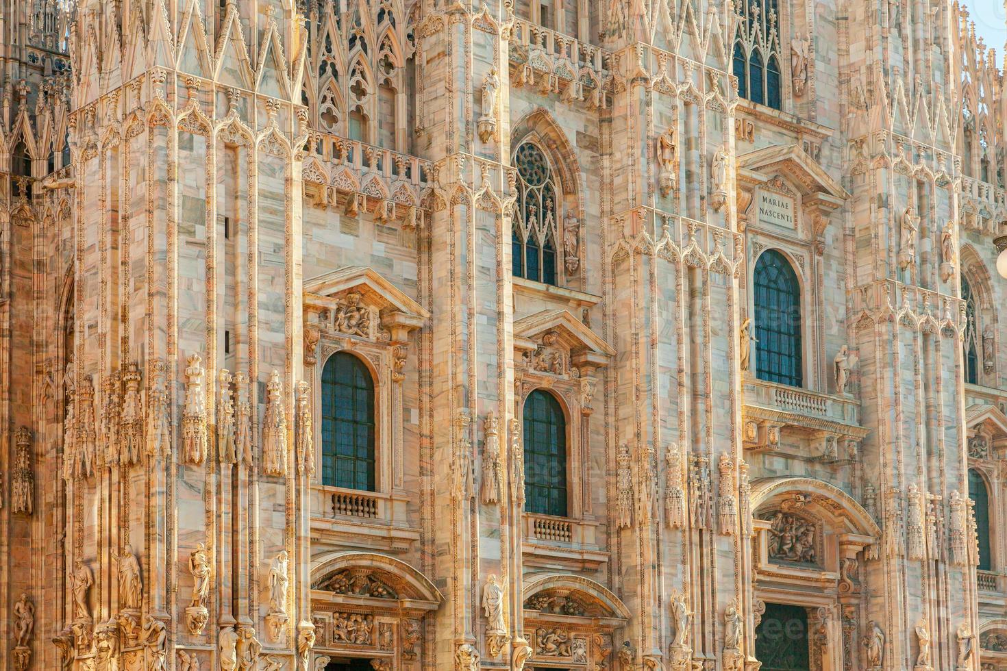 Famous church Milan Cathedral Duomo di Milano with Gothic spires and white marble statues. Top tourist attraction on piazza in Milan Lombardia Italy. Wide angle view of old Gothic architecture and art photo