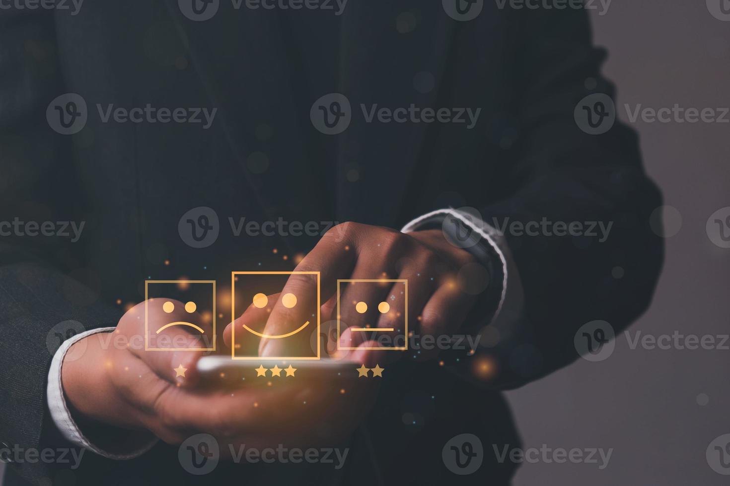 Business man holding phone wiht virtual screen on the happy Smiley face icon to give satisfaction in service. rating very impressed. Customer service and Satisfaction concept photo