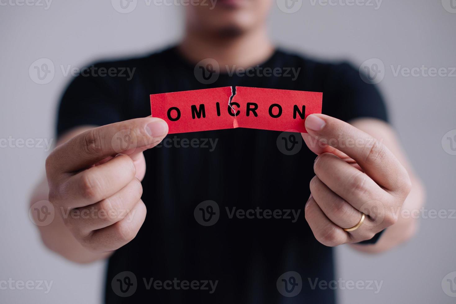 Man with a stethoscope Tear the red paper with the word Omicron. New generation vaccine against Coronavirus South African variant. Omicron variant of SARS-CoV-2. New B.1.1.529 Variant of concern photo