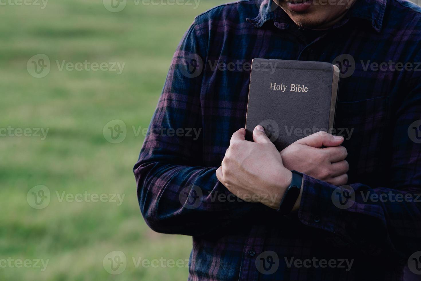 Man in hold and hugging holy bible on the bench. christian praying believe concept. photo