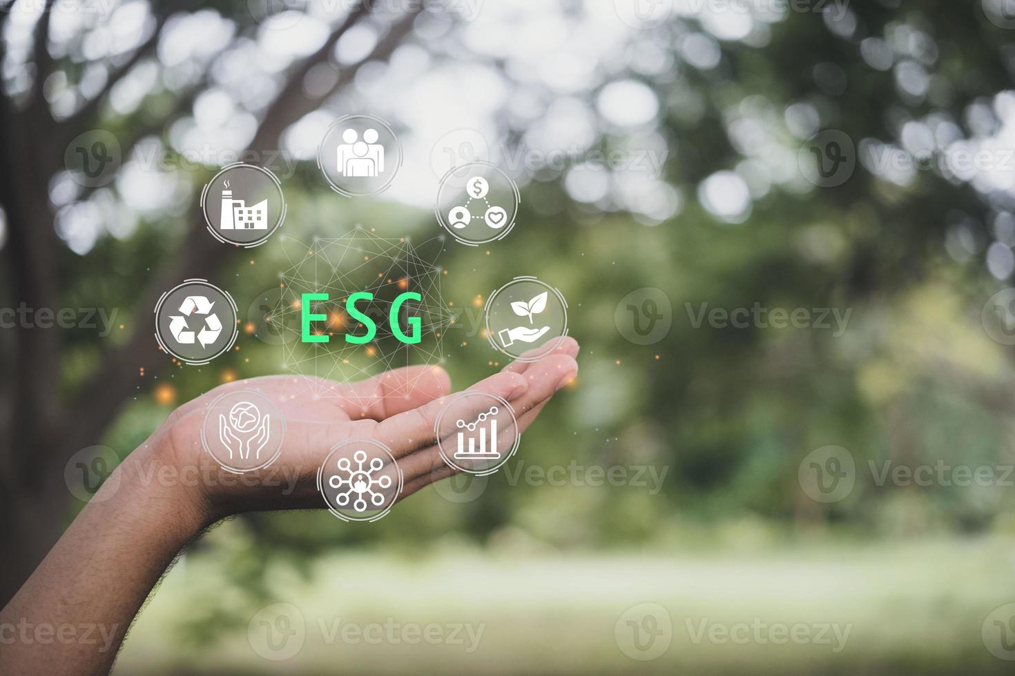 ESG icon concept in the hand for environmental, social, and governance in sustainable and ethical business on the Network connection on a nature background. photo