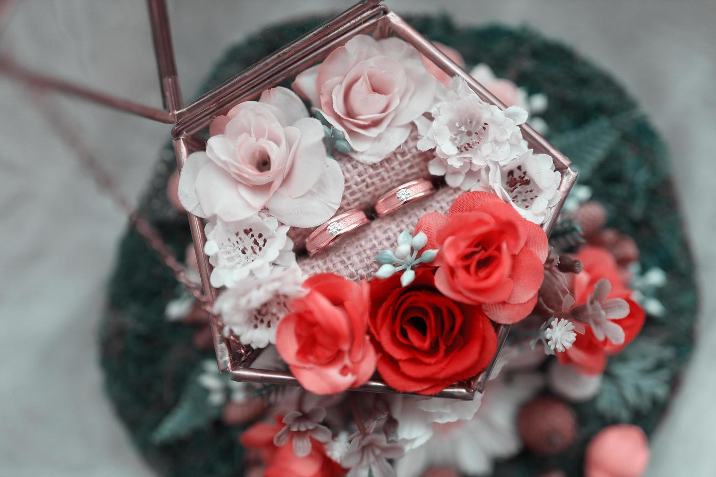 A pair of wedding rings on a bouquet of flowers photo