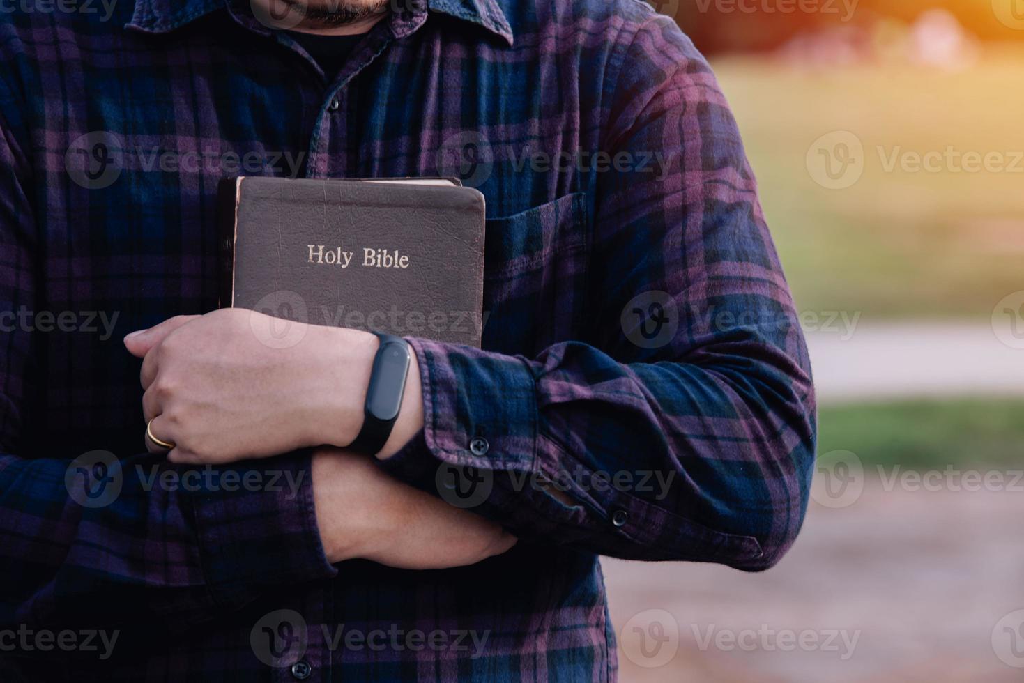 Man in hold and hugging holy bible on the bench. christian praying believe concept. photo