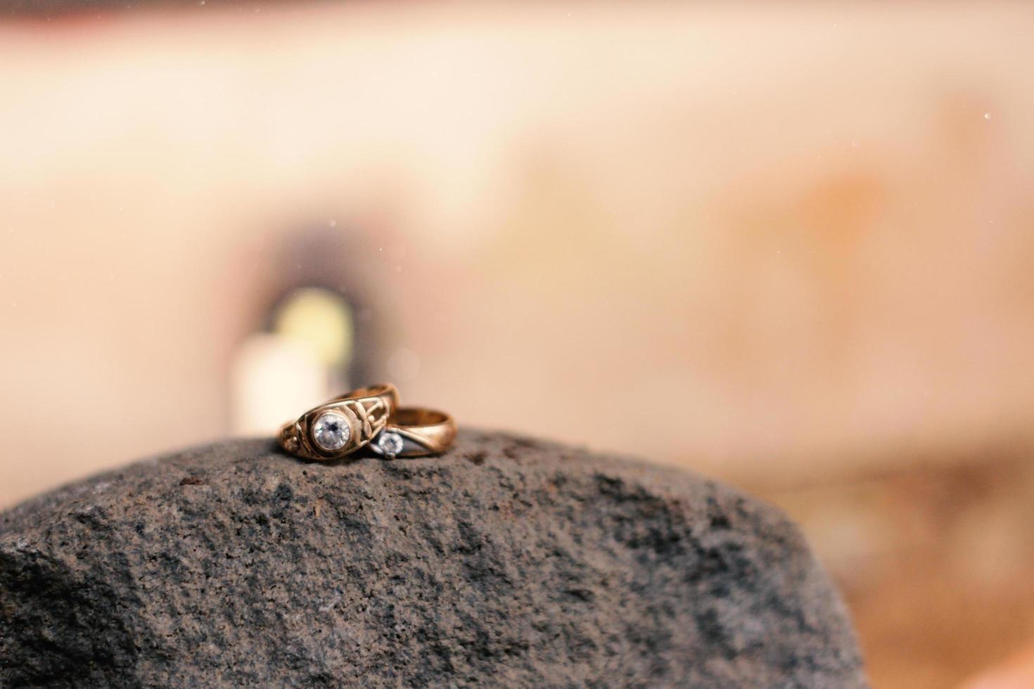 A pair of wedding rings on a rock. Wedding rings symbol love family. photo