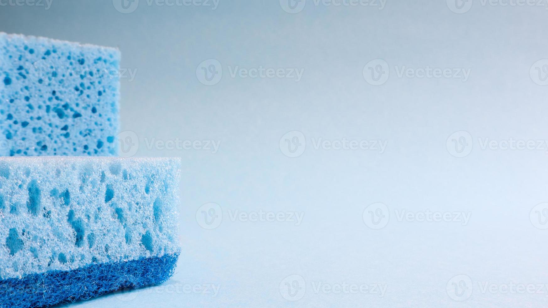 Two blue sponges used for washing and erasing dirt used by housewives in everyday life. They are made of porous material such as foam. Detergent retention, which allows you to spend it economically photo