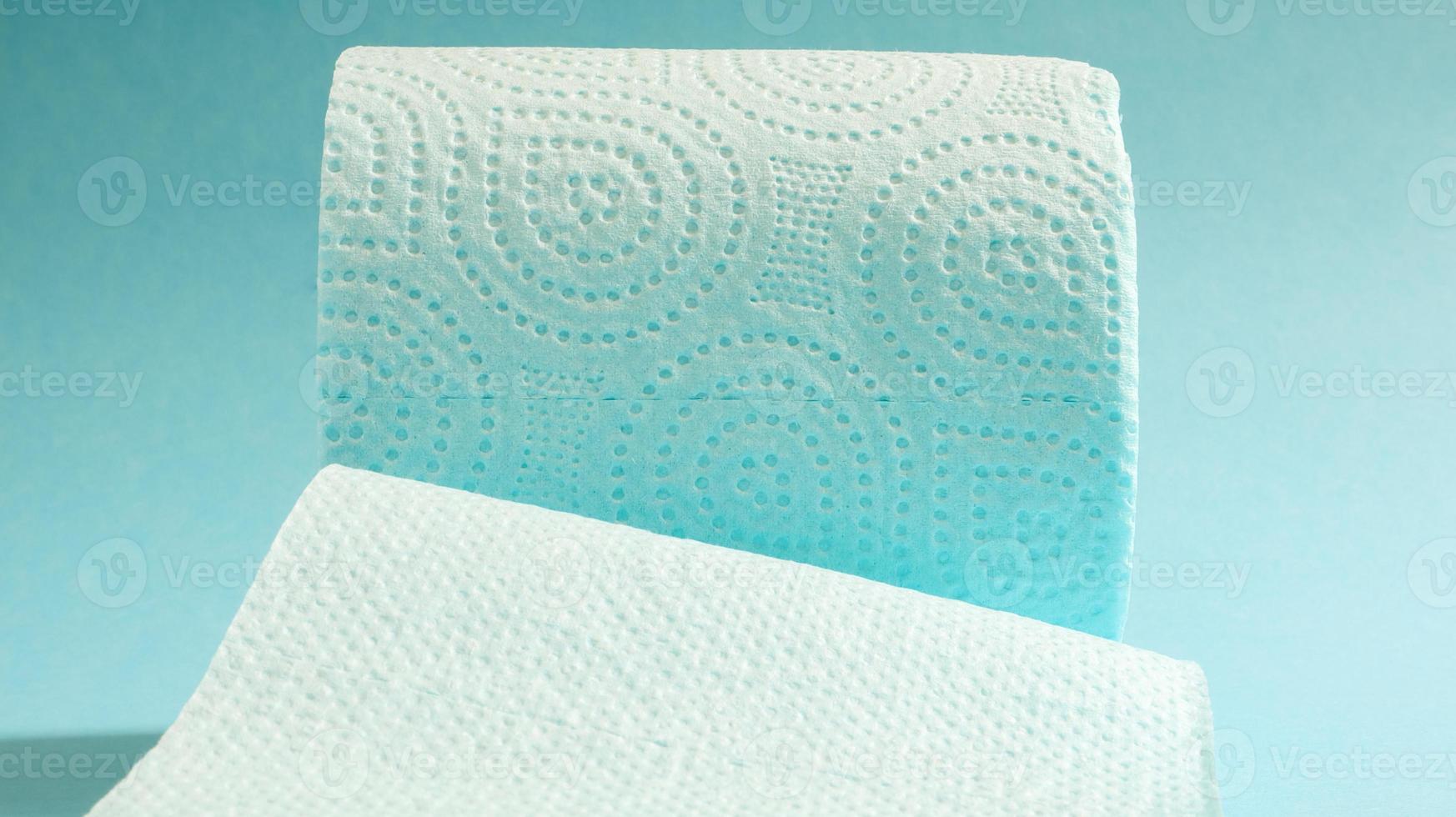 Blue roll of modern toilet paper on a blue background. A paper product on a cardboard sleeve, used for sanitary purposes from cellulose with cutouts for easy tearing. Embossed drawing photo