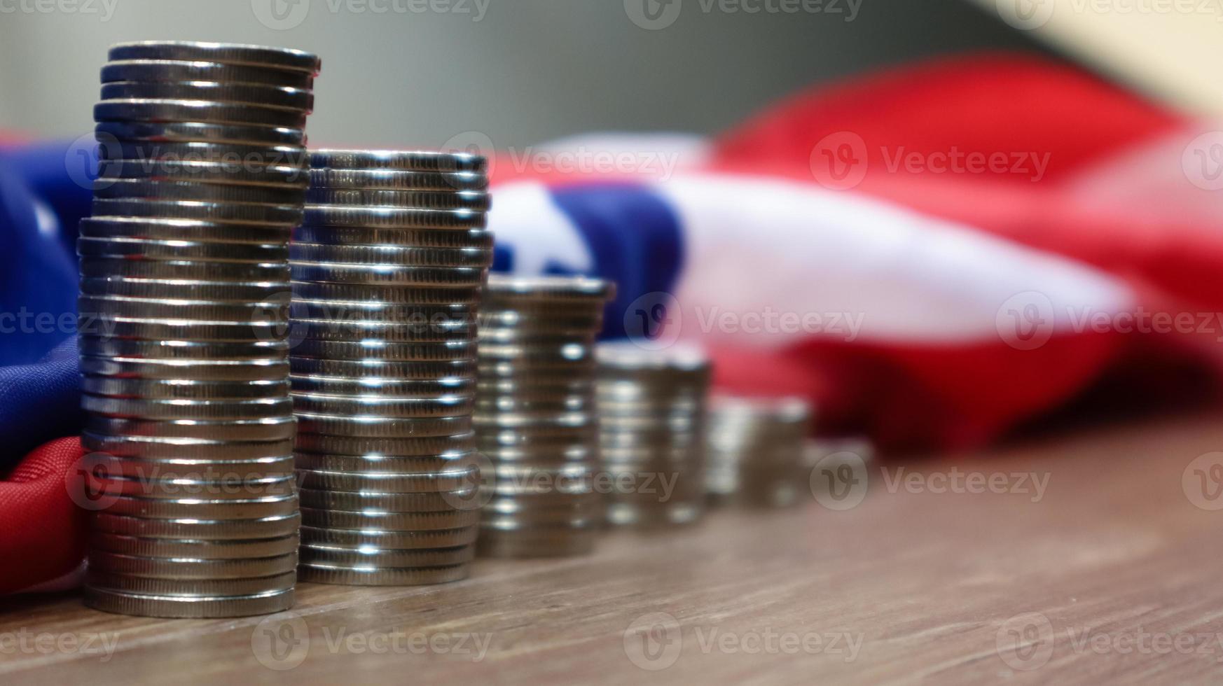 American coins with the flag of the United States of America. Investment concept, business finance and money saving. US coins stacked against the background of the American flag. Selective focus. photo