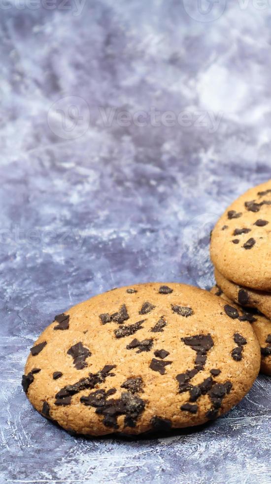 Soft, freshly baked chocolate chip cookies on a gray marble kitchen countertop. American traditional sweet pastry pastry, delicious homemade dessert. Culinary background. Vertical photography photo