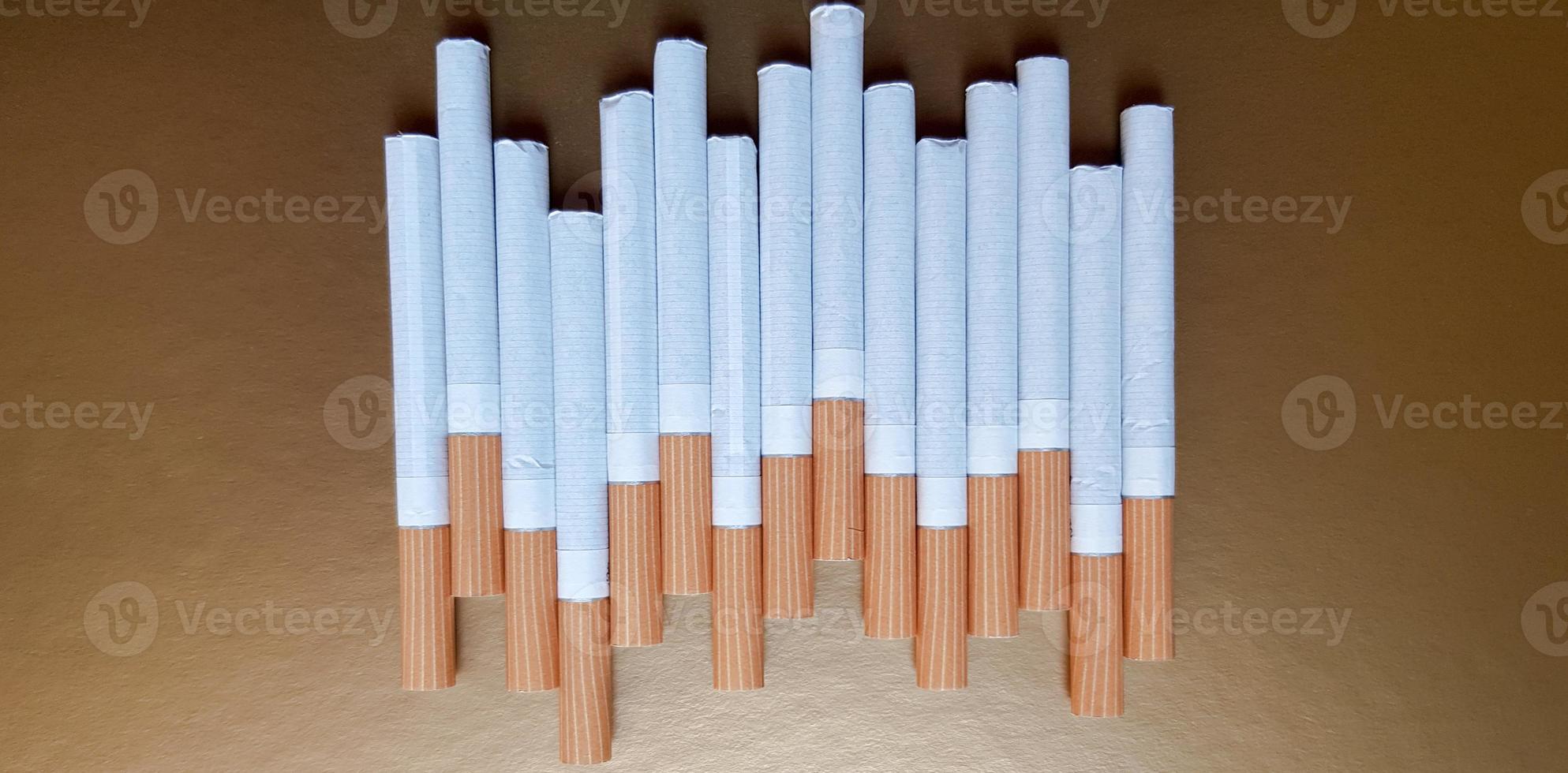 Image of several commercial cigarettes. pile of cigarettes on a gold background or concept of anti-smoking campaign, tobacco photo