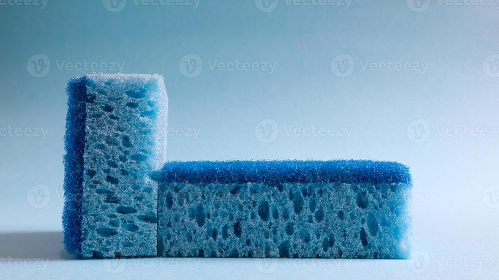 Two blue sponges used for washing and erasing dirt used by housewives in everyday life. They are made of porous material such as foam. Detergent retention, which allows you to spend it economically photo