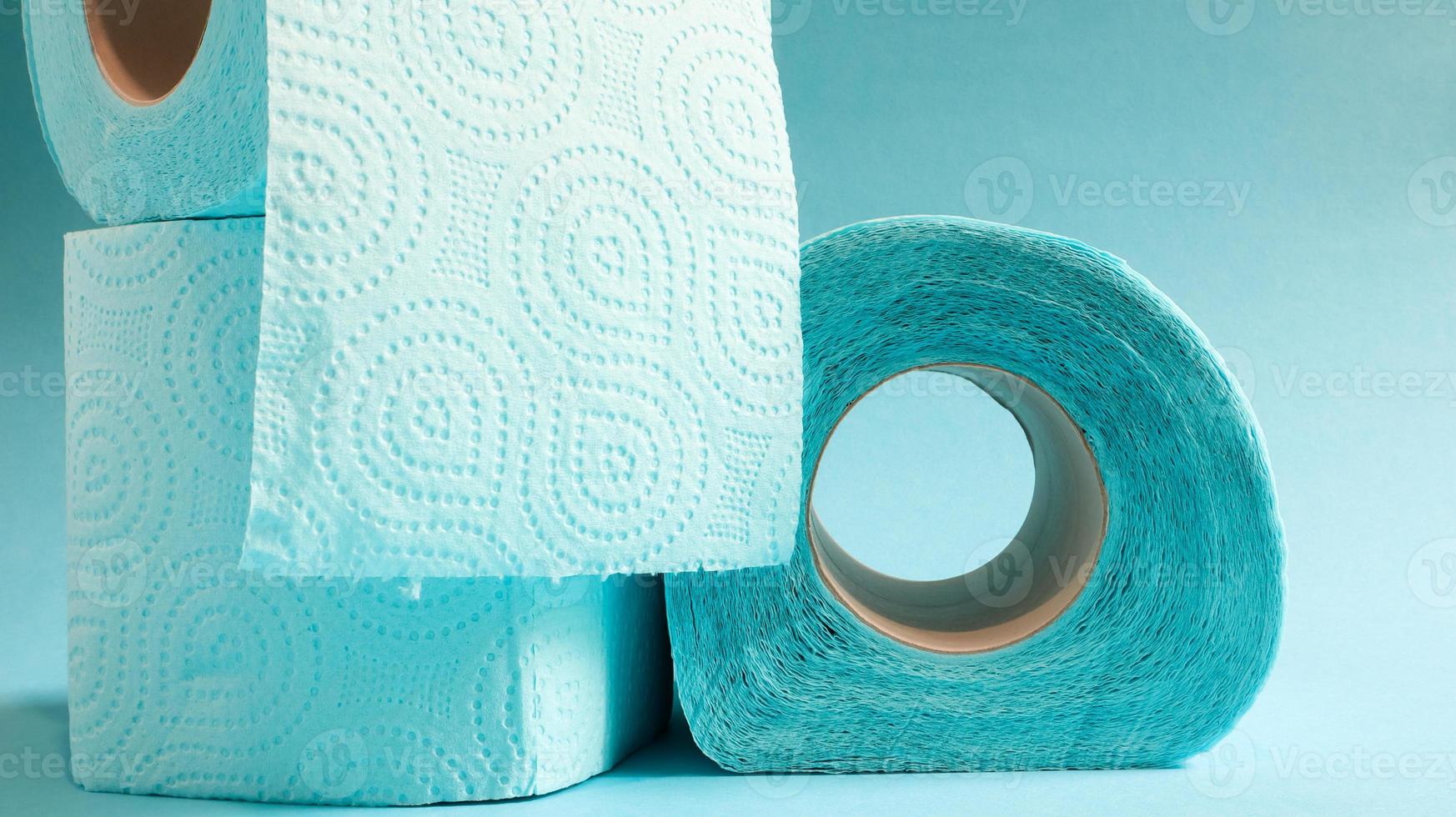 rollo azul de papel higiénico moderno sobre un fondo azul. un producto de papel en una funda de cartón, utilizado con fines sanitarios de celulosa con recortes para facilitar el desgarro. dibujo en relieve foto