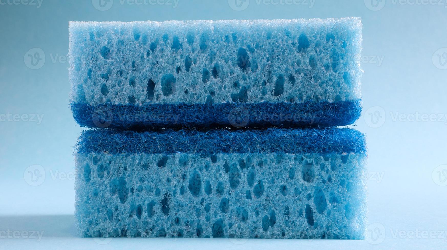 dos esponjas azules usadas para lavar y borrar la suciedad que usan las amas de casa en la vida cotidiana. están hechos de material poroso como la espuma. retención de detergente, que te permite gastarlo económicamente foto