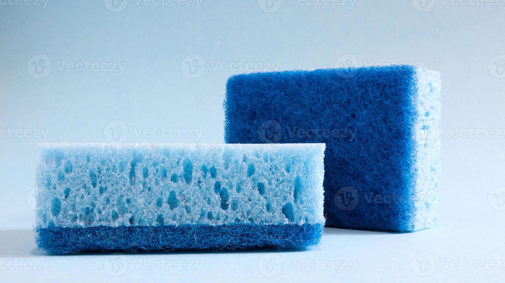 Two blue sponges used for washing and erasing dirt used by housewives in everyday life. They are made of porous material such as foam. Detergent retention, which allows you to spend it economically photo
