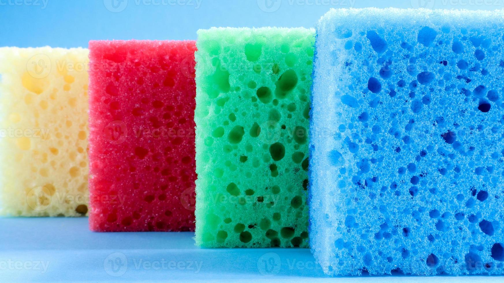 muchas esponjas azules, rojas, amarillas y verdes se usan para lavar y limpiar la suciedad que usan las amas de casa en la vida cotidiana. están hechos de material poroso como la espuma. buena retención de detergente foto