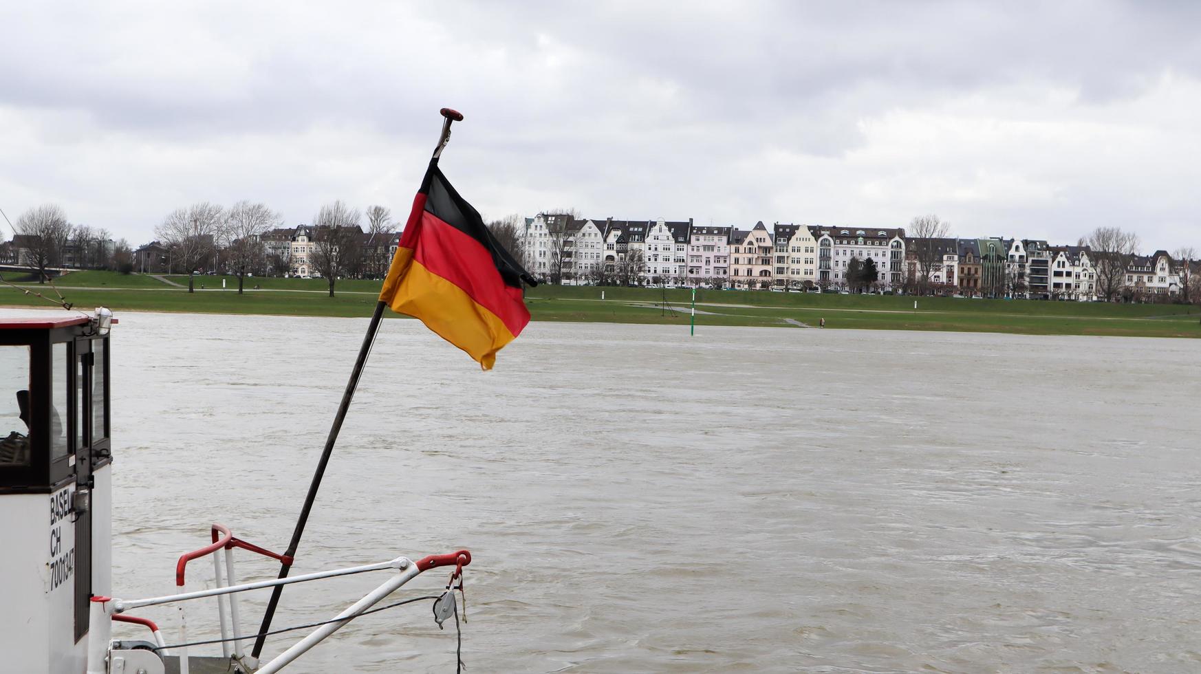 dusseldorf, alemania - 20 de febrero de 2020. bandera de alemania en un barco en el rin. la bandera nacional alemana en la parte trasera de un barco de pasajeros ondea en el viento. transatlántico en el momento de dusseldorf. foto