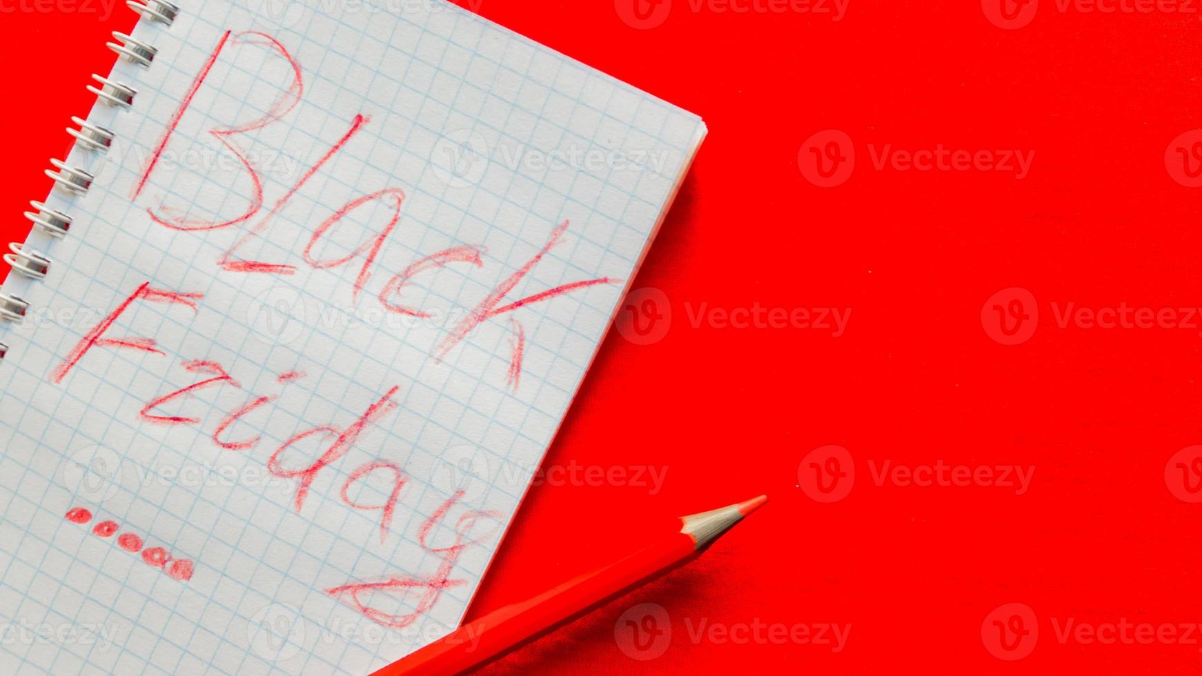 Black friday sale text written on a notepad with a red pencil on a red background. Background, holiday concept. Black Friday - International Day of Shopping, Promotions, Discounts, Sales. photo