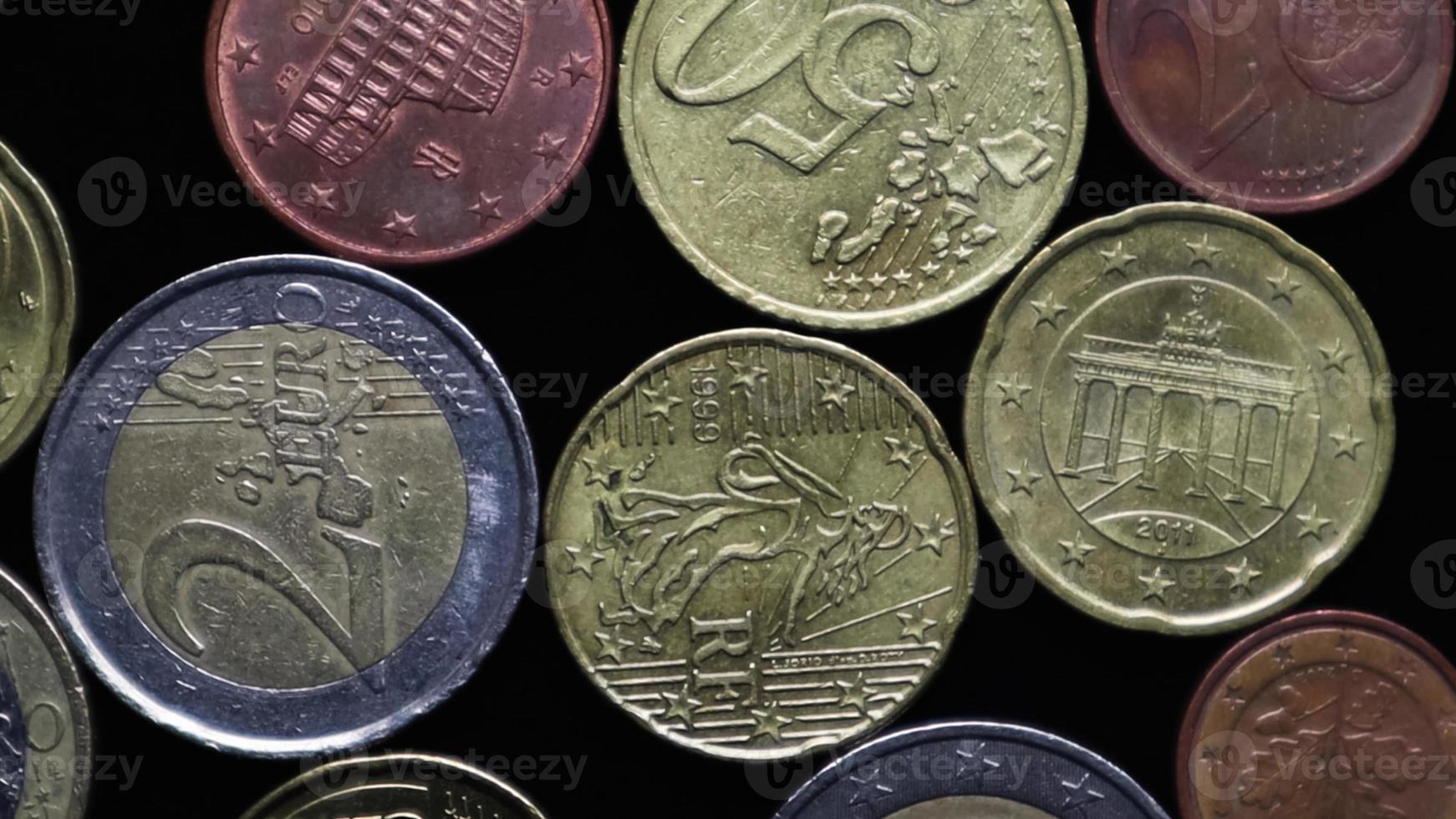 Euro coins cents on a black background close-up. Play of light and rotation. Macro photography. Flat lay. Financial crisis and bankruptcy concept during coronavirus pandemic. photo