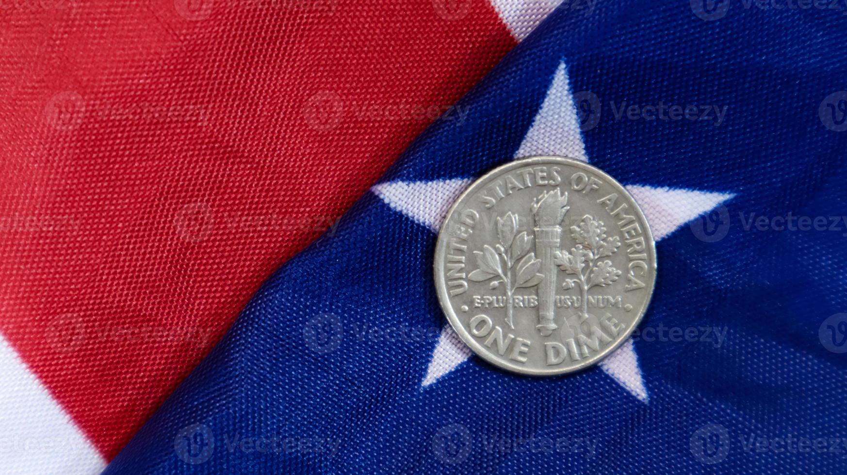 una moneda de 1 centavo de dólar americano se encuentra en la bandera americana. la moneda es un centavo sobre la bandera de los estados unidos. foto